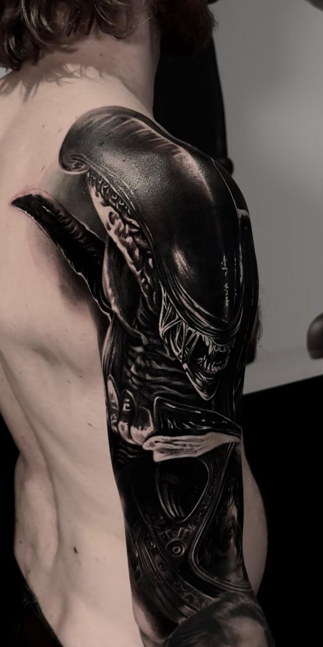 Detailliertes Alien Tattoo auf Arm